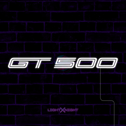 White Ford Mustang Shelby GT500 lettering LED neon sign displayed on a dark brick wall