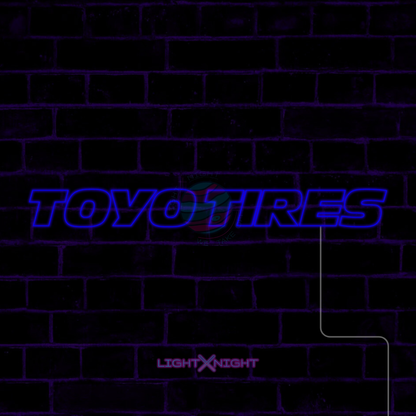 Blue Toyo Tires lettering LED neon sign displayed on a dark brick wall