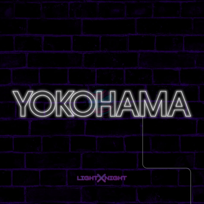 White Yokohama lettering LED neon sign displayed on a dark brick wall