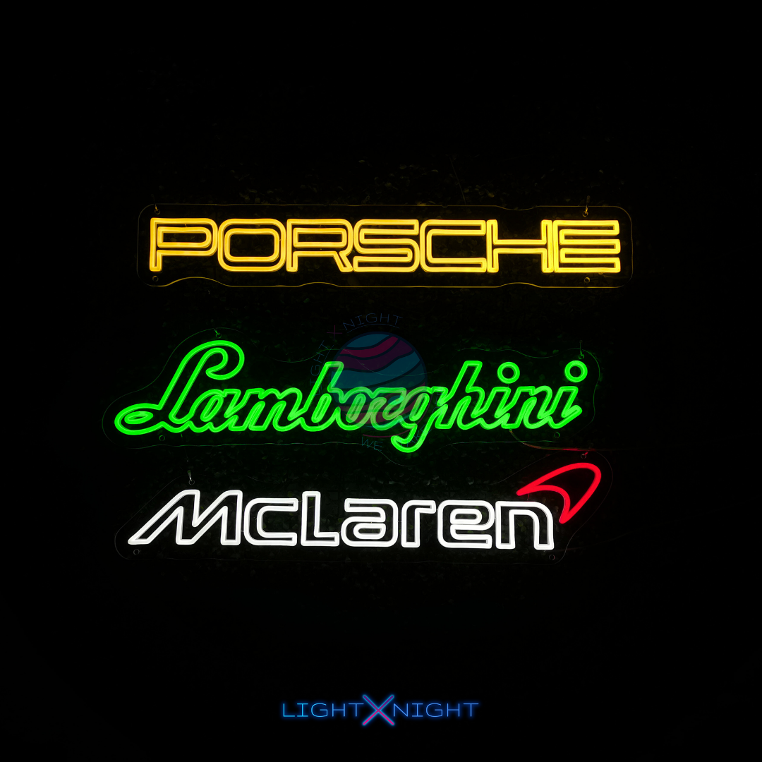 Neon signs of Porsche, Lamborghini, and McLaren logos on a black background.